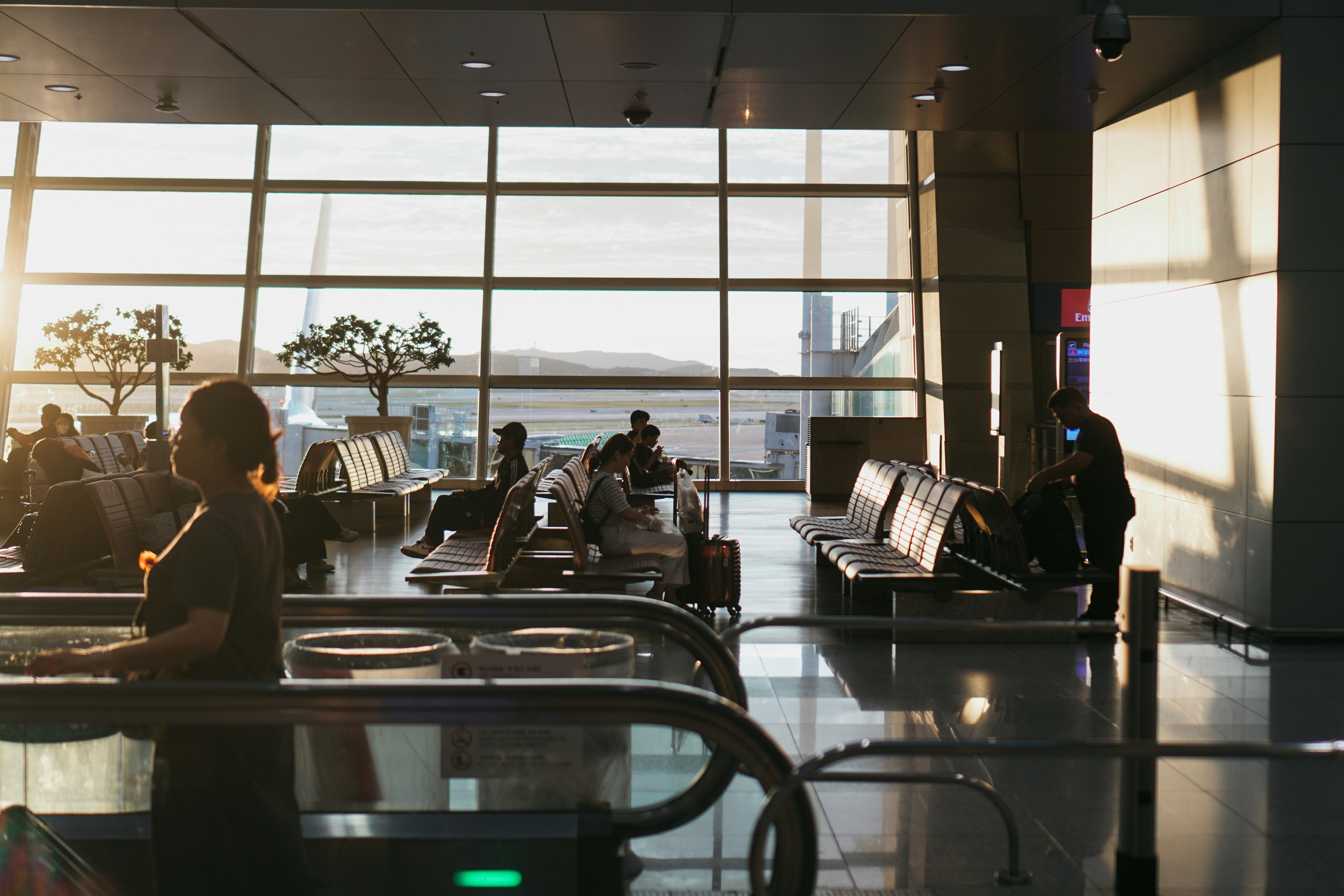 Passageiro aguardando voo em aeroporto com mala